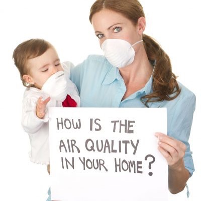 a woman holding a sign with a child wearing a mask